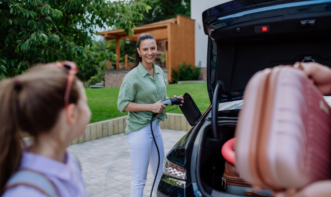 happy mother talking to child beside car